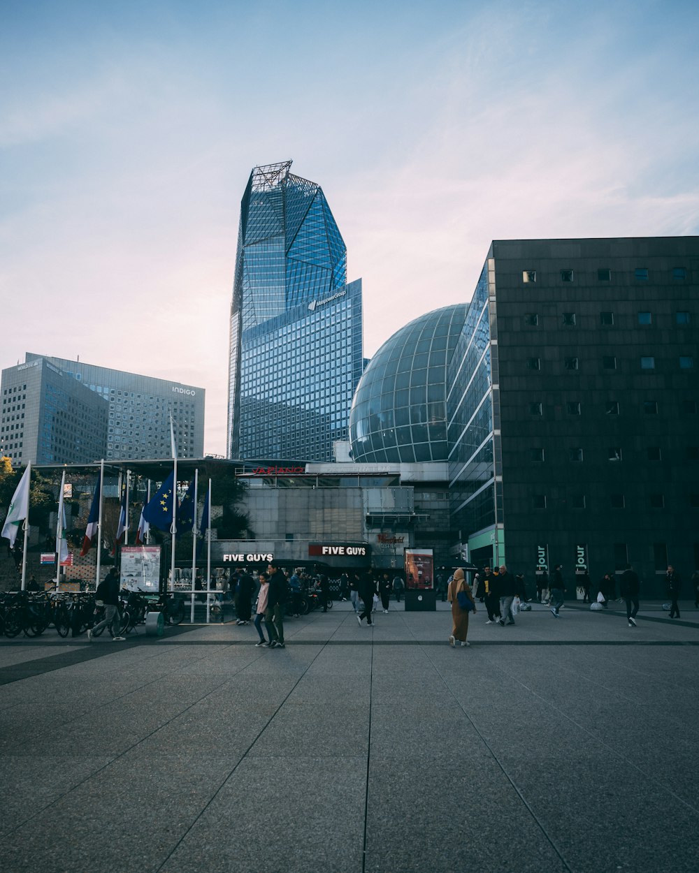 a group of people walking around a city square