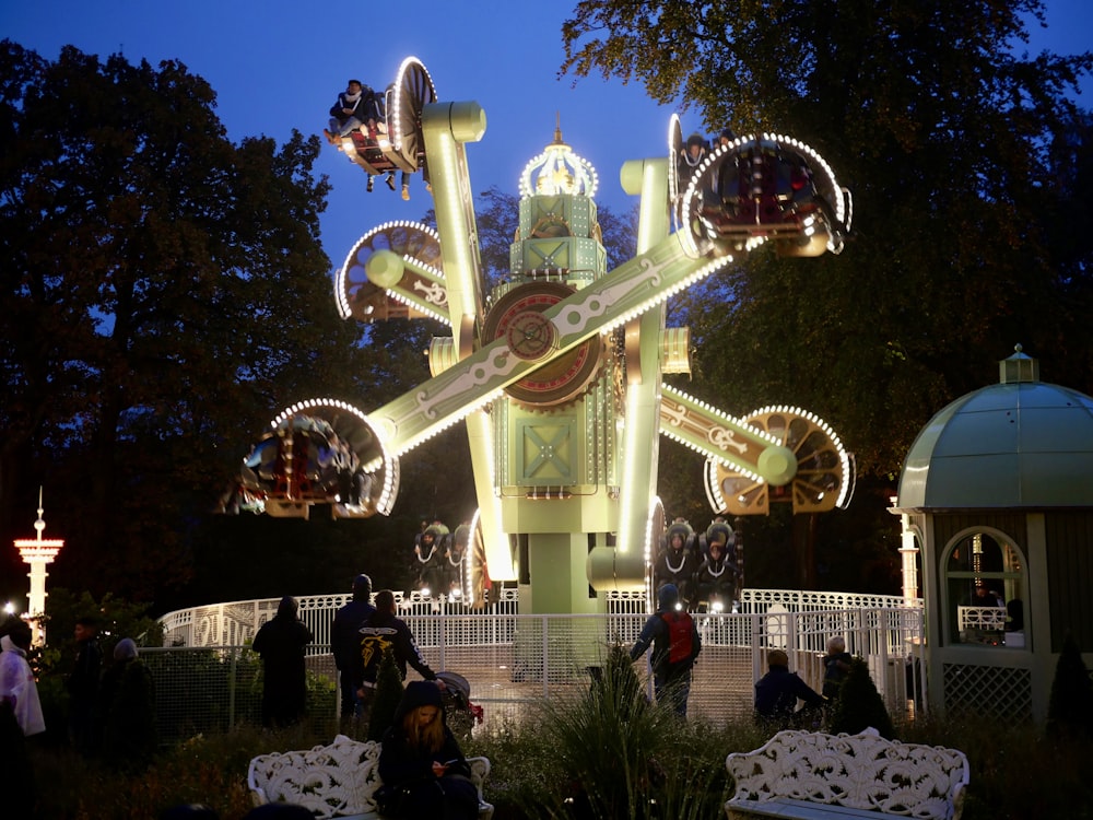 a carnival ride at night with people standing around