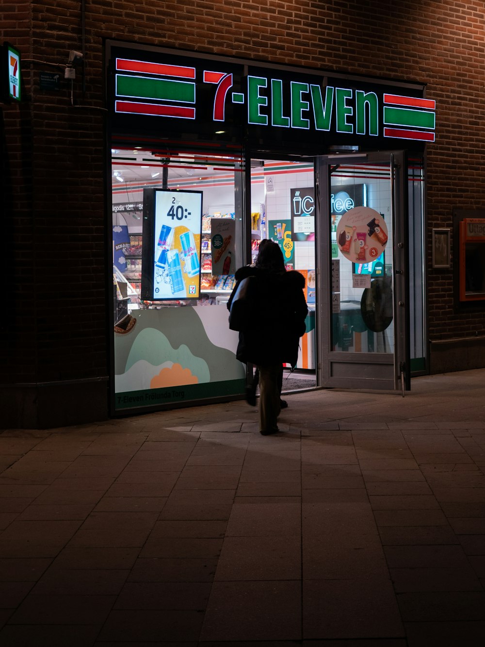 a person walking out of a store at night
