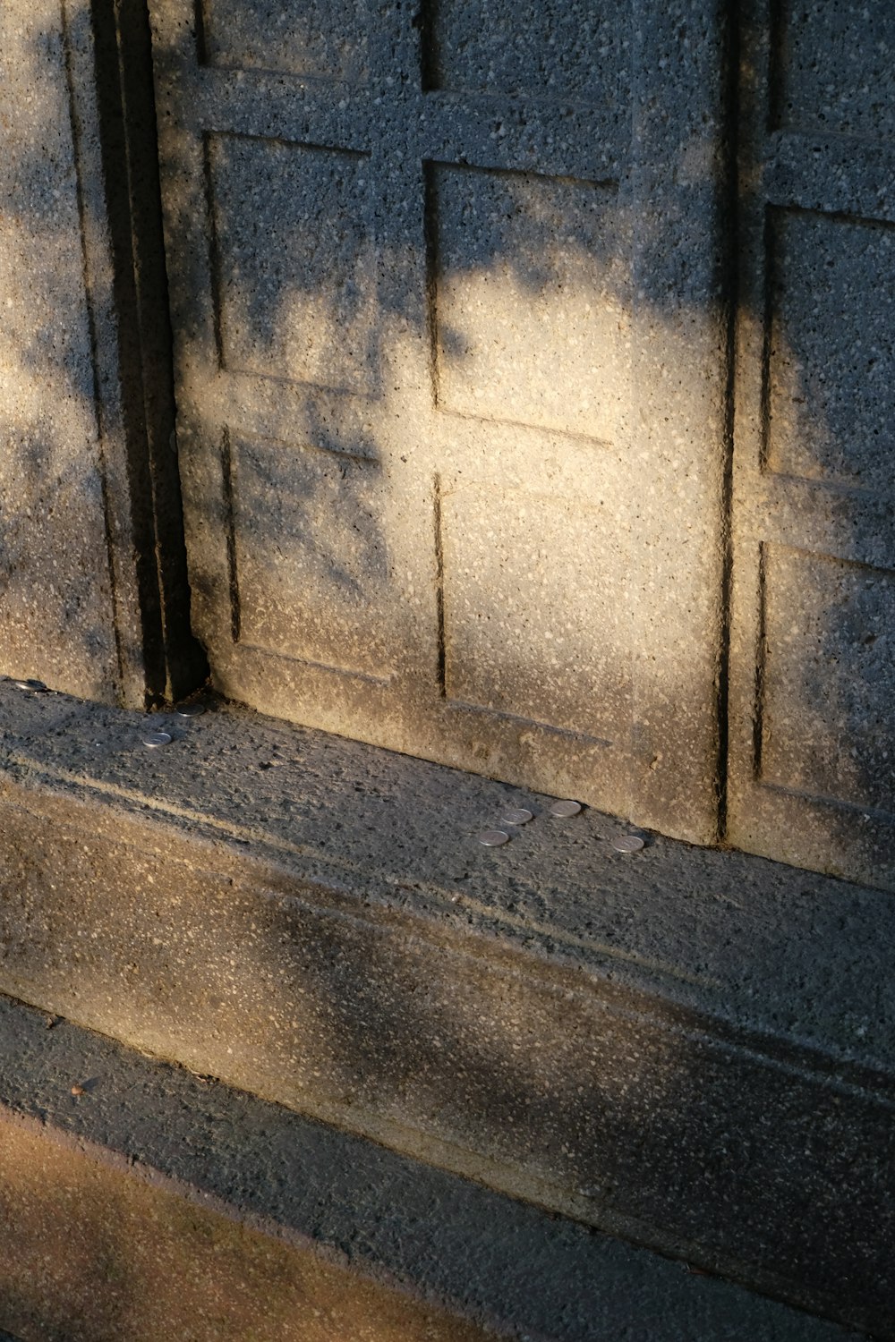 a wooden bench sitting next to a stone wall