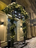 An elegant front porch decorated with holiday lights.