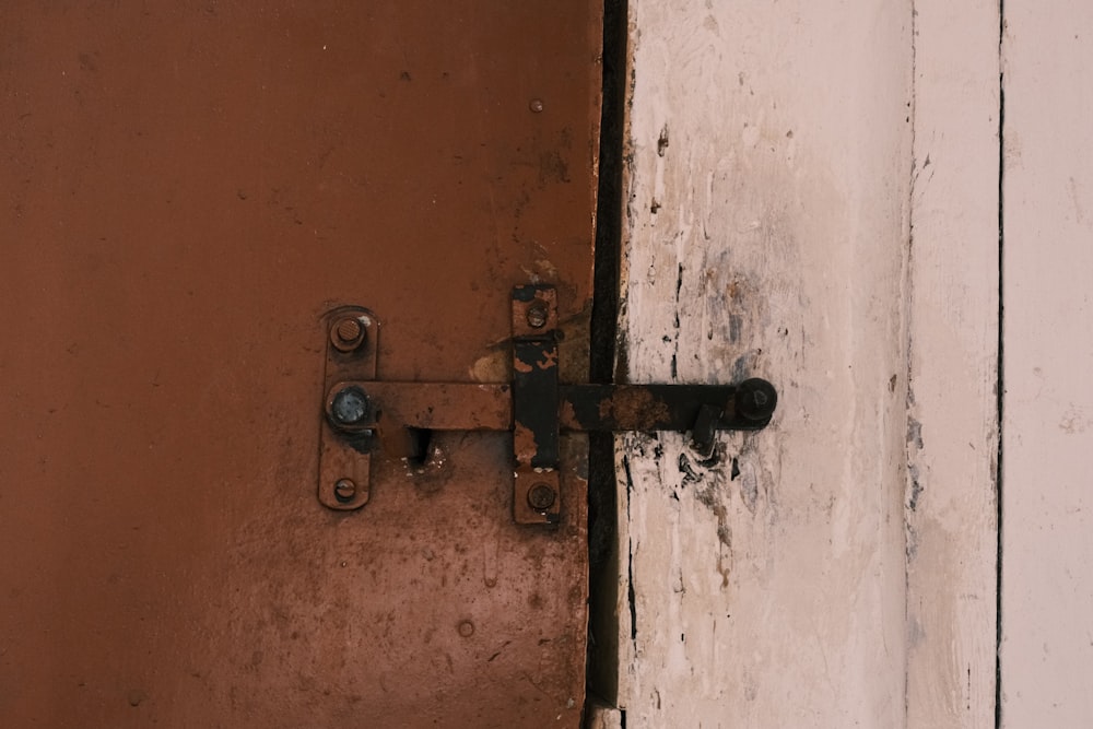 a rusted metal door handle on a white door