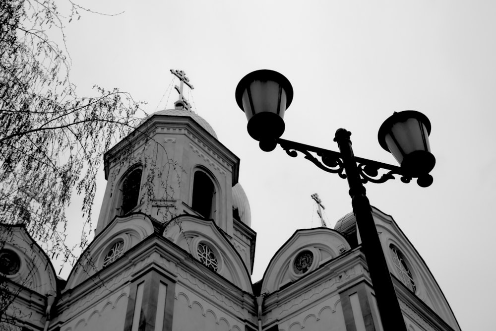 a black and white photo of a street light and a church