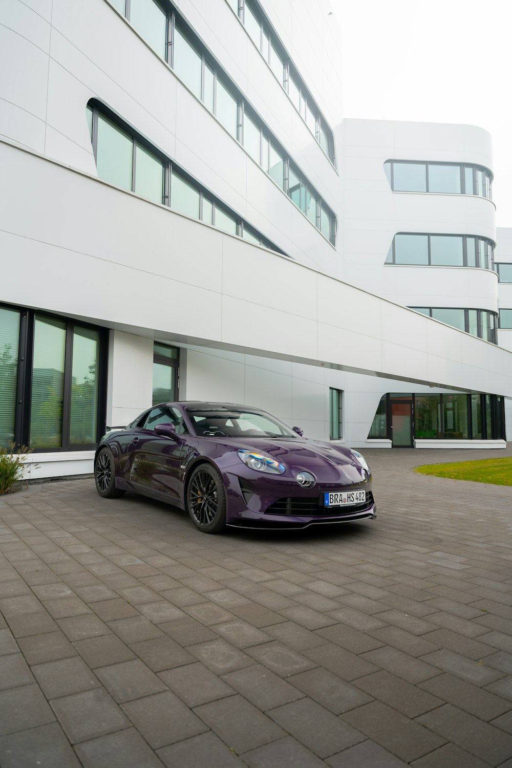 a purple sports car parked in front of a building