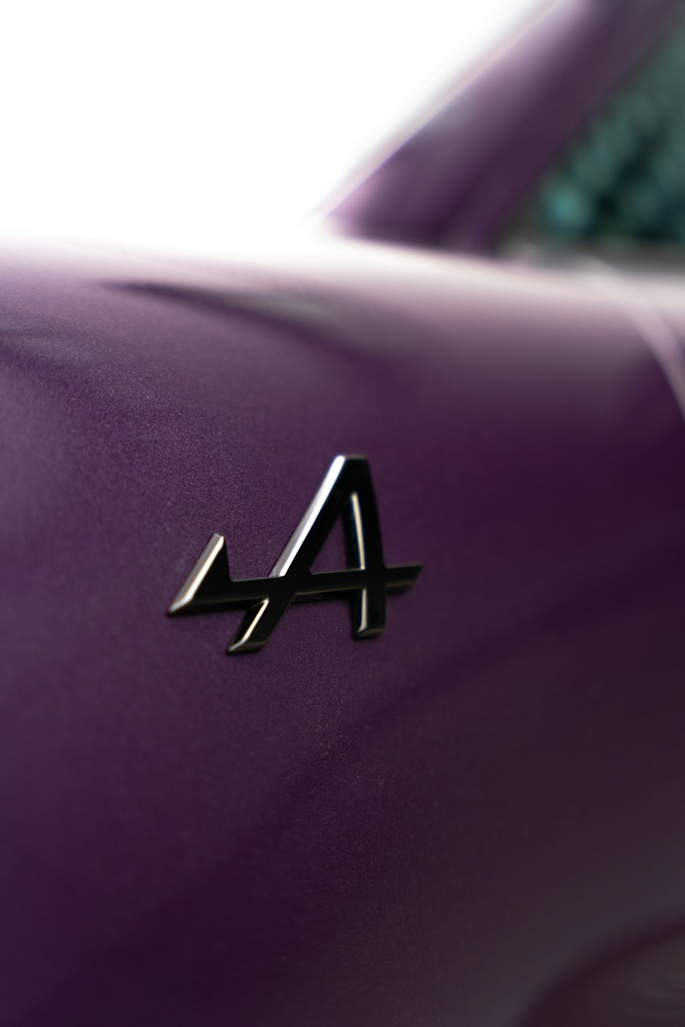 a close up of a purple car with a logo on it