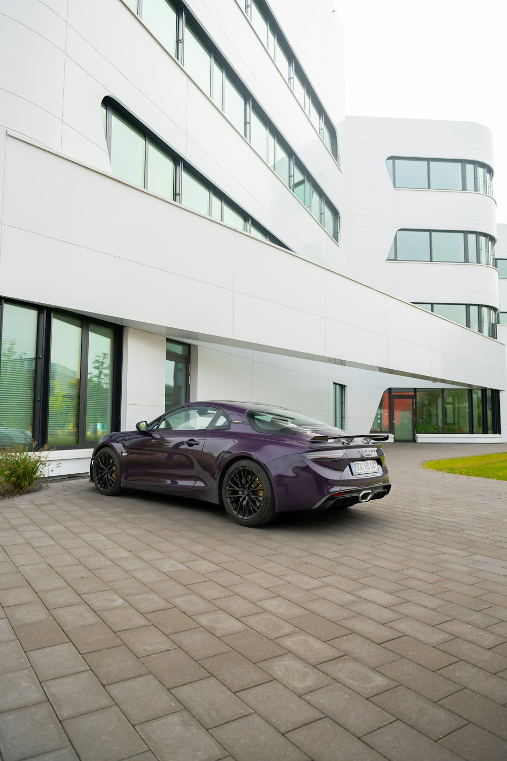 a purple sports car parked in front of a building