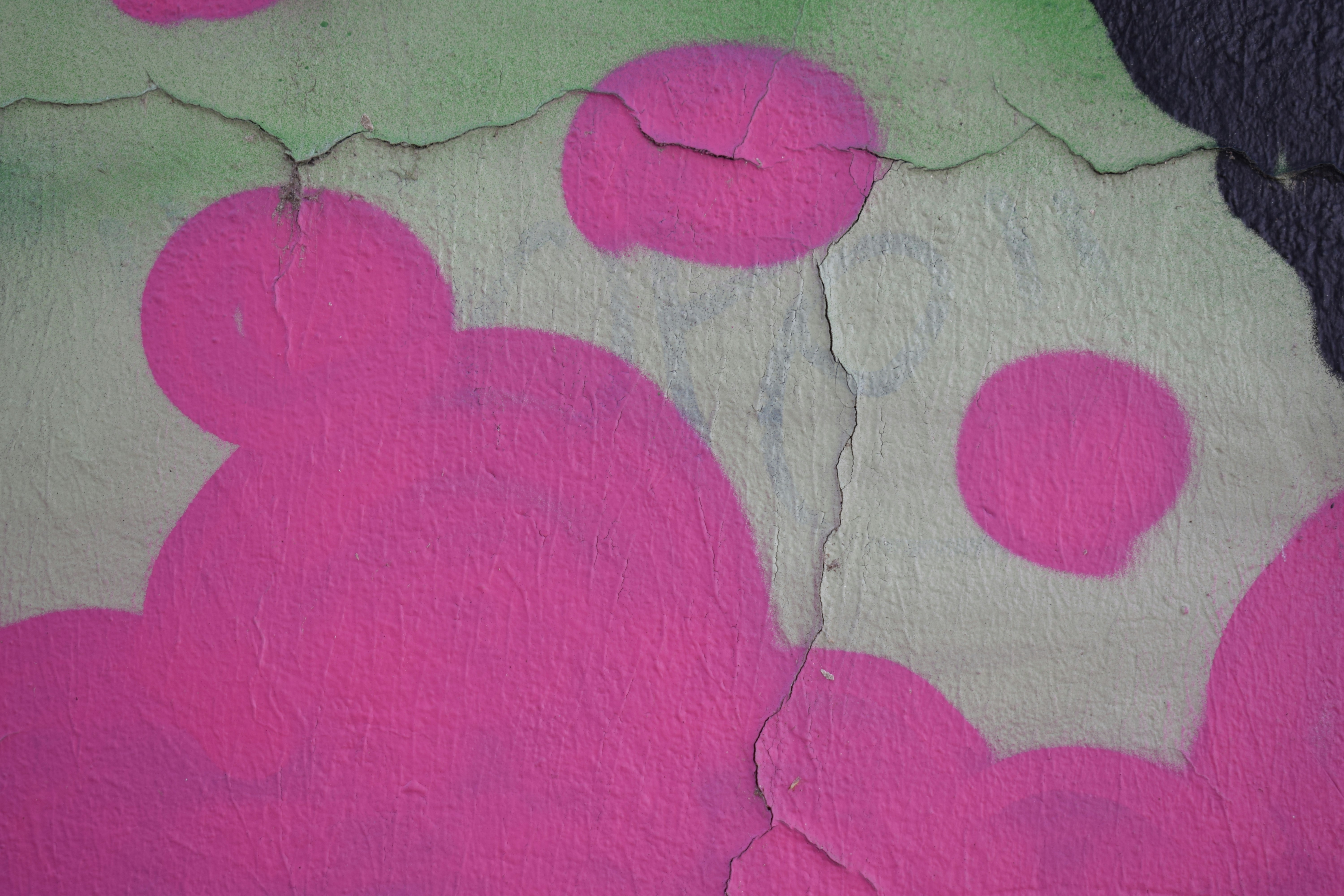 a wall with pink and green paint on it