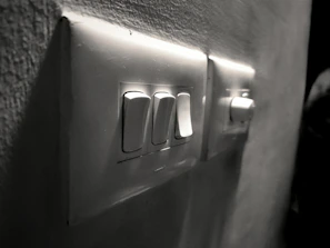 Close-up of a hand flipping a circuit breaker switch with a soft background.