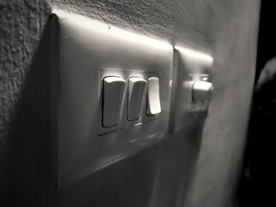 Close-up of a sleek electrical switch panel with multiple switches in a modern office setting.