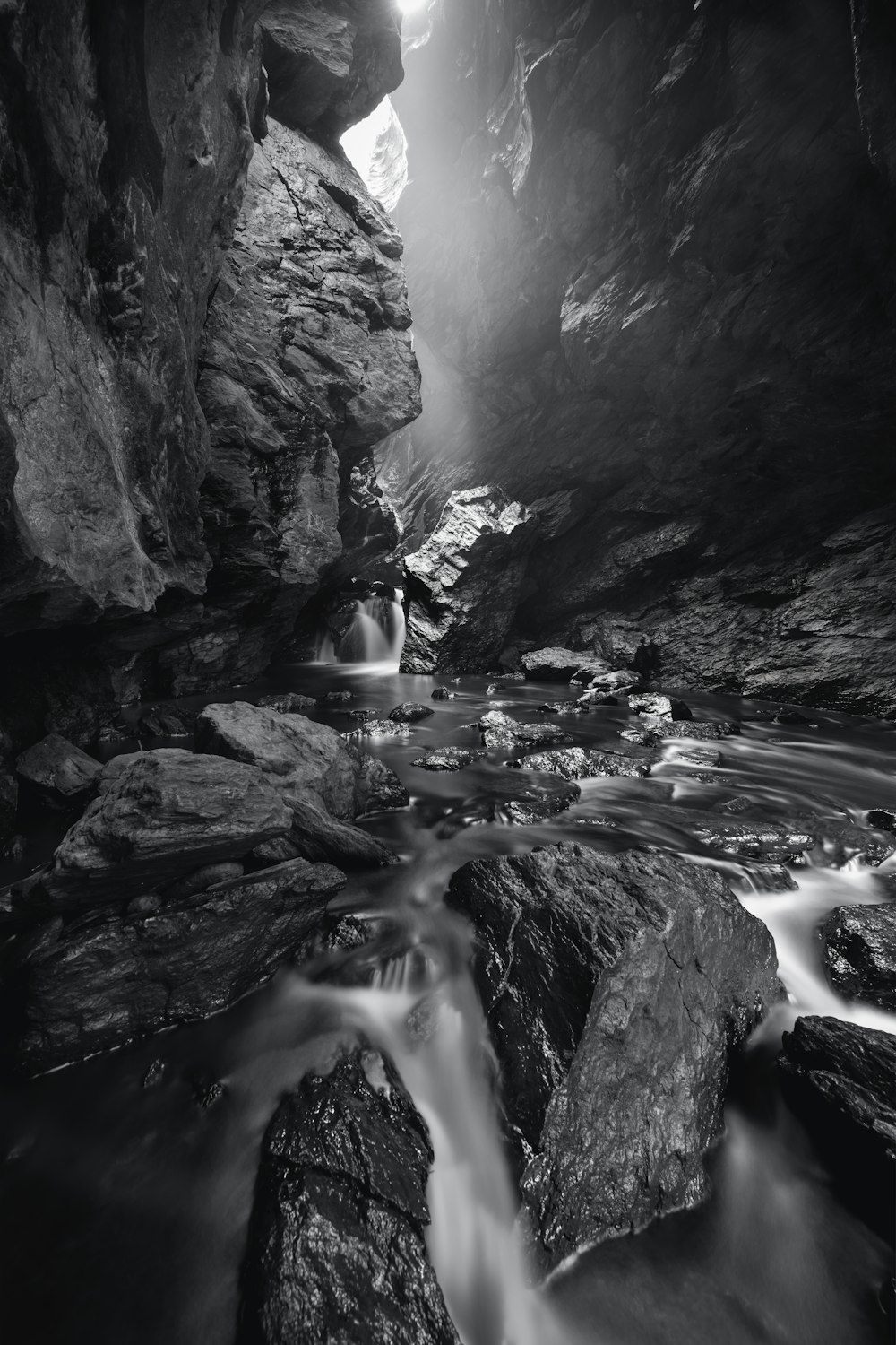 a black and white photo of a stream in a cave