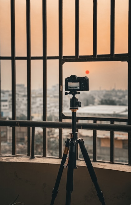 A wide shot of a director behind the camera, framed by a golden hour cityscape