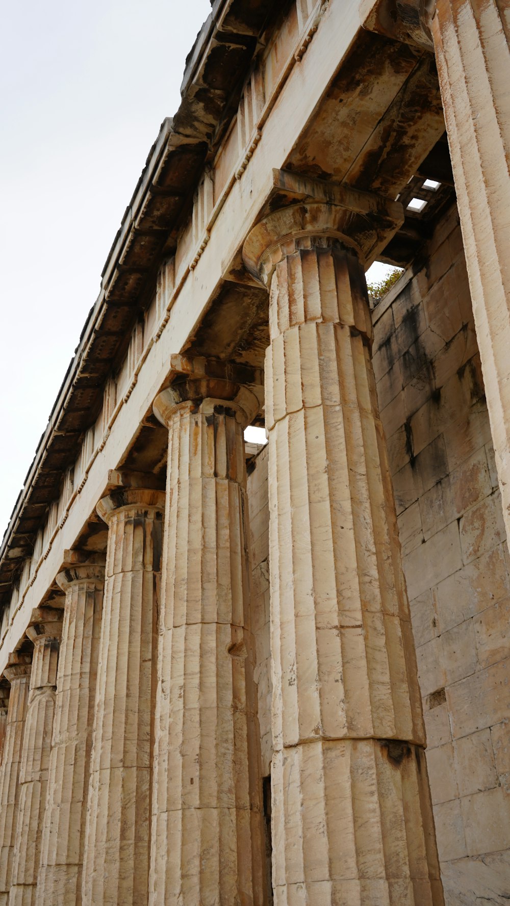 a row of large stone pillars under a bridge