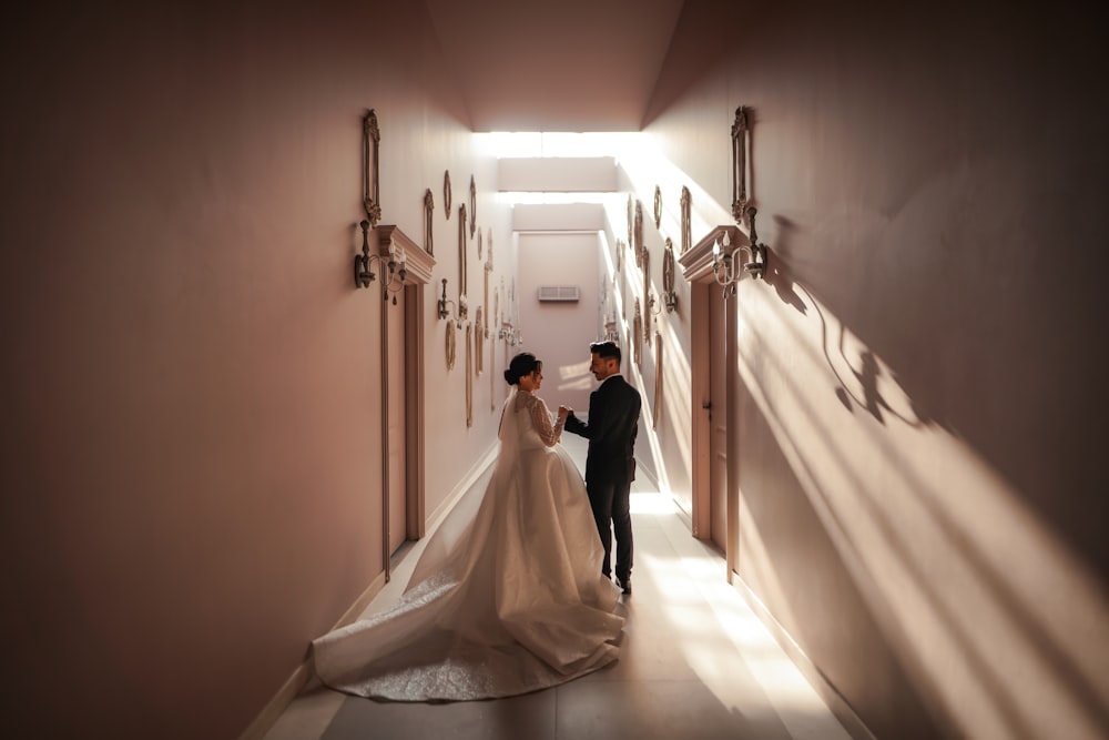 a bride and groom walking down a hallway
