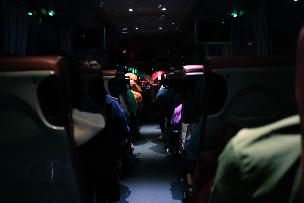 a group of people sitting on a bus in the dark