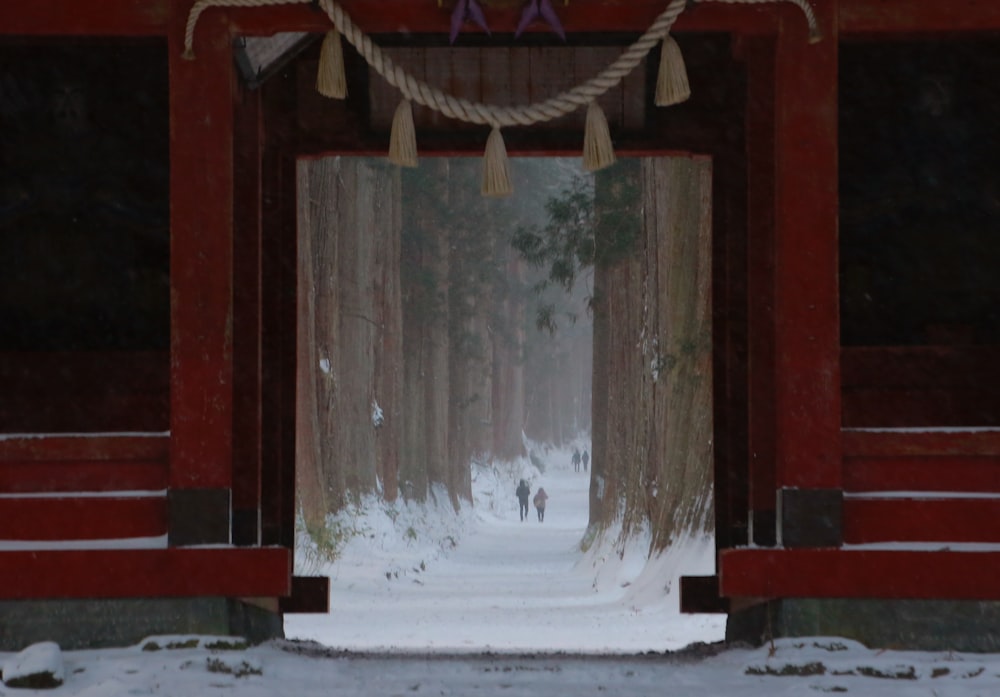 a couple of people walking down a snow covered road