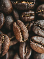 Close-up of roasted Arabica coffee beans from Nepal, showcasing their rich texture and deep brown color.