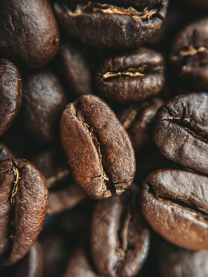 A close-up of freshly roasted coffee beans in a burlap sack, showcasing their rich color and texture.