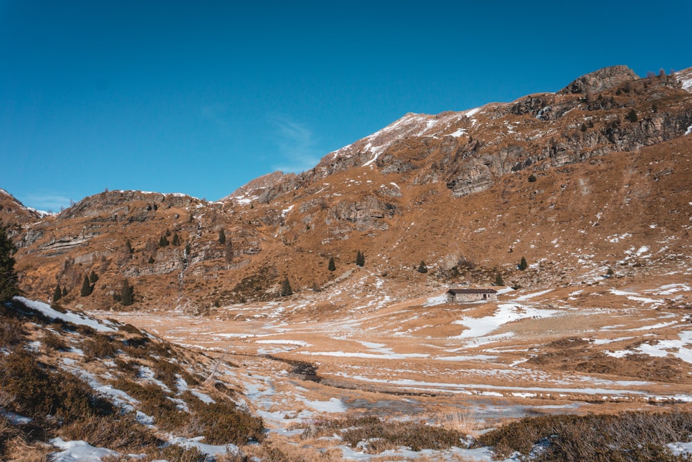 a snow covered mountain side with a road in the foreground