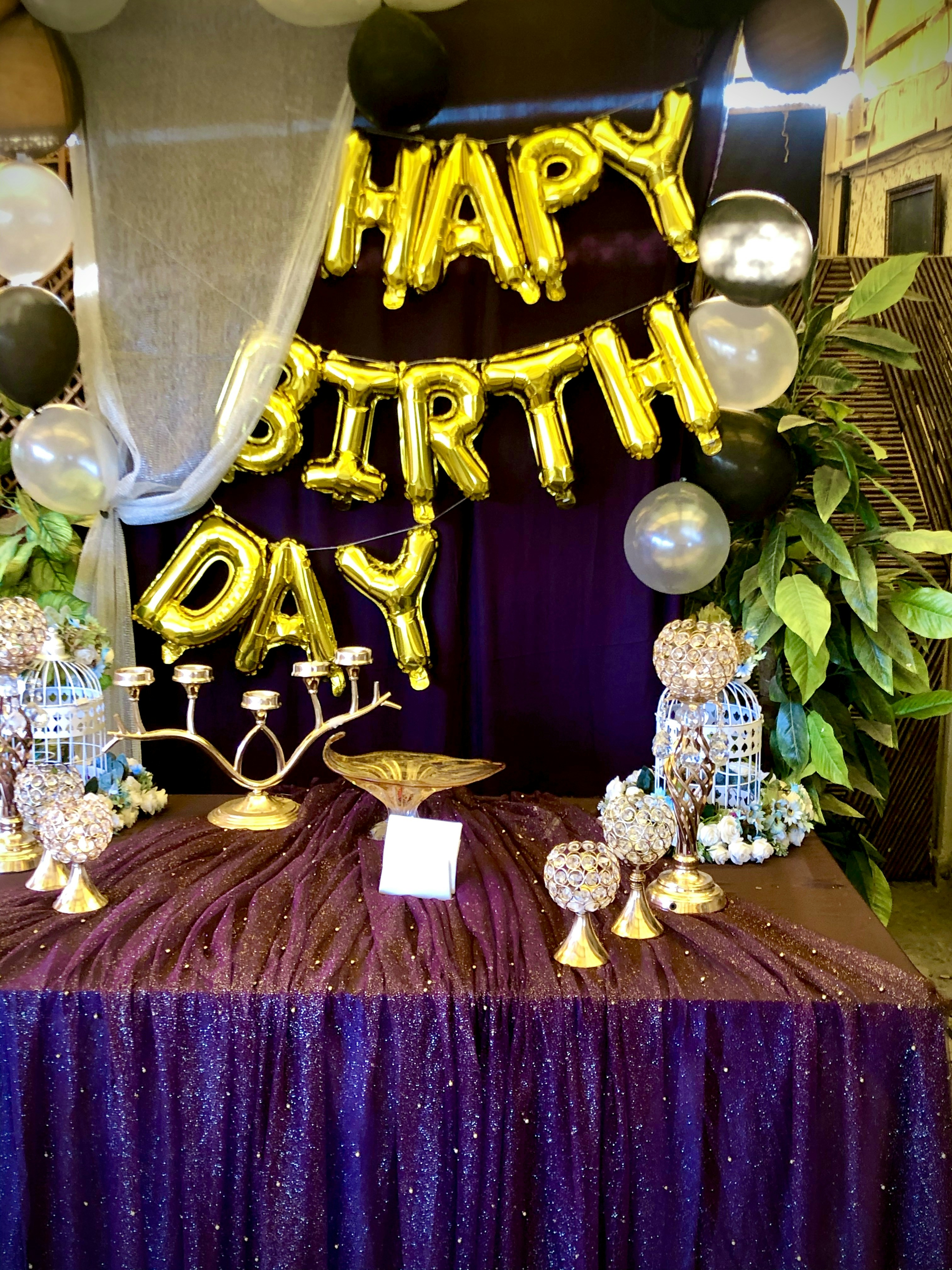 Gold and purple birthday balloon bouquet arrangement on white background bright party setting