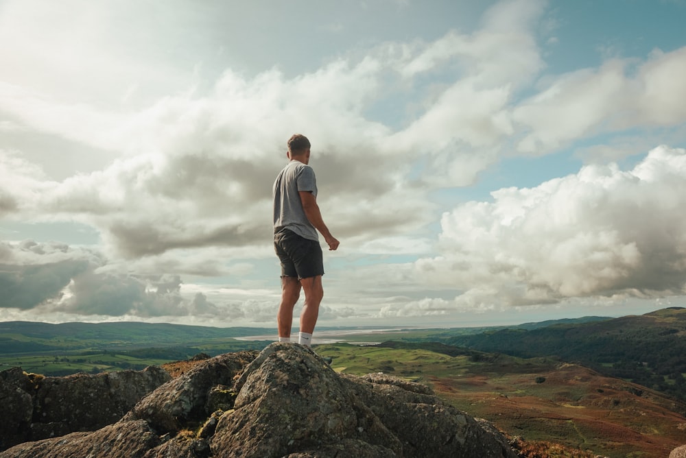 a man standing on top of a large rock