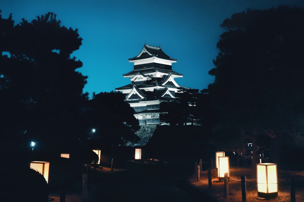 a tall white building sitting next to a forest