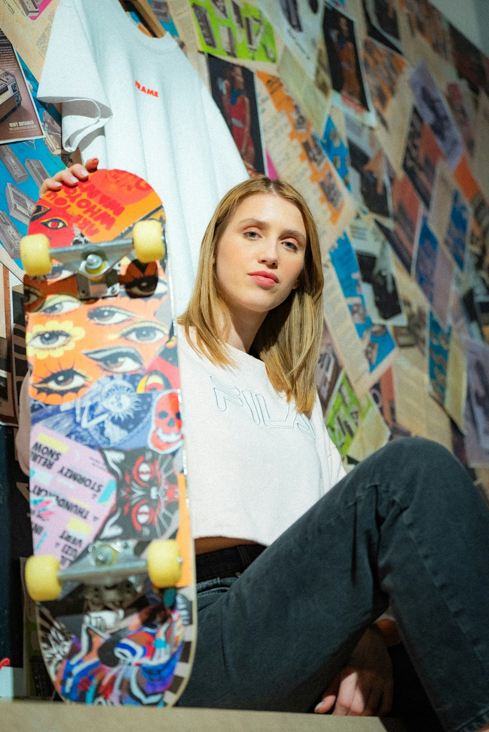 a woman sitting on the floor with a skateboard