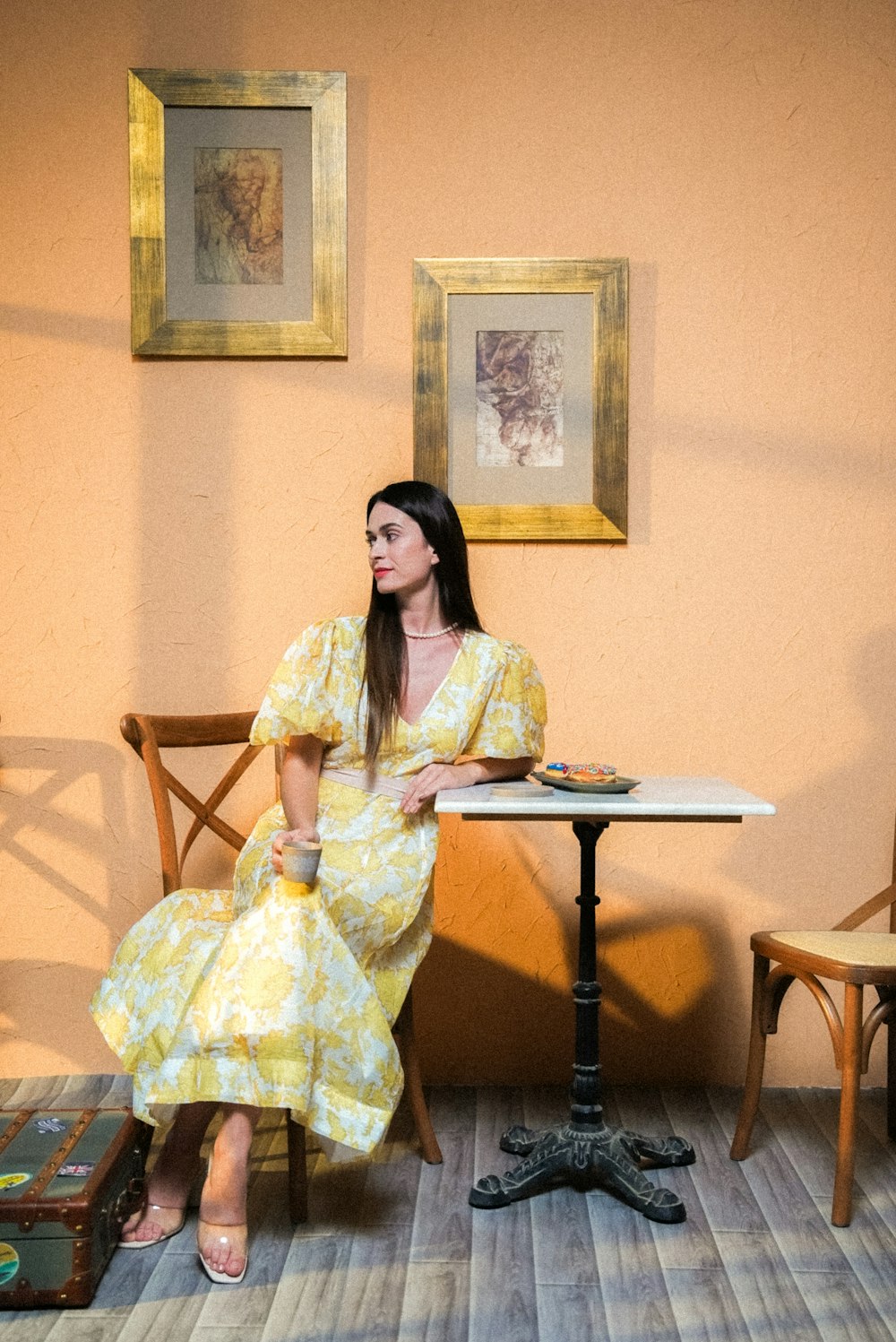 a woman in a yellow dress sitting at a table