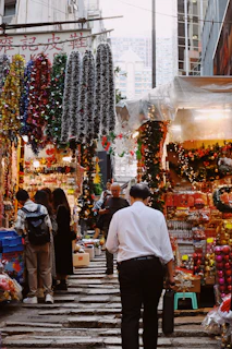 A vibrant street fair with food stalls and families walking among festive decorations.