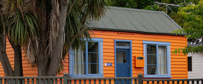 a small orange house with a blue door