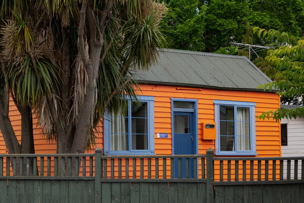 Une petite maison orange avec une porte bleue