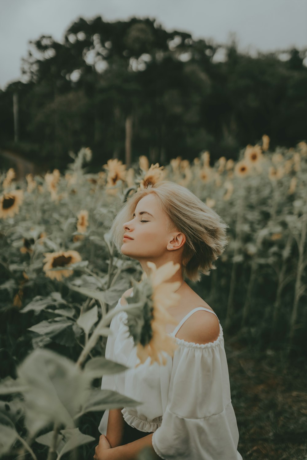 a woman standing in a field of sunflowers