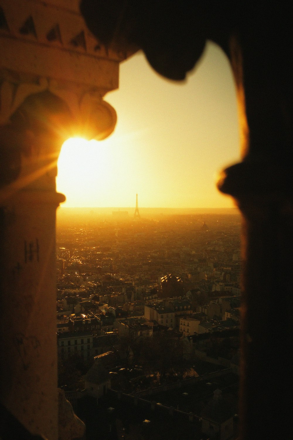 the sun is setting over the city of paris