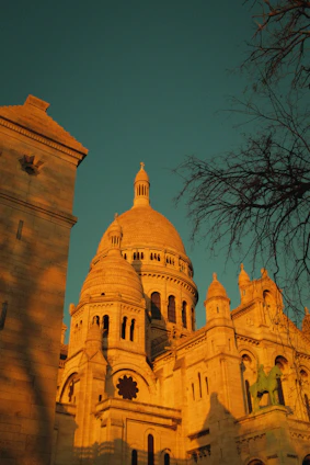 A warm, inviting photo of the Sagrada Família bathed in golden afternoon light, highlighting its intricate facades.
