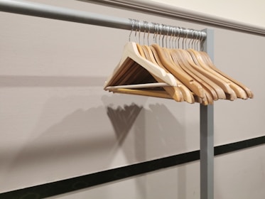 A collection of sturdy black and blue hangers arranged neatly on a rack.