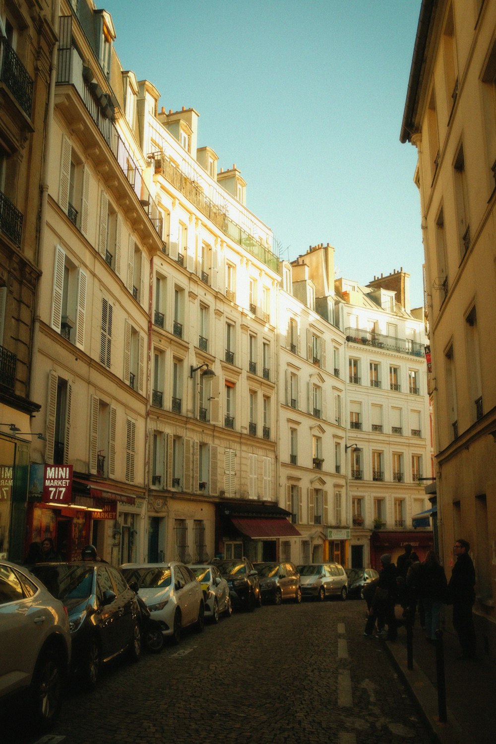 a city street lined with tall buildings and parked cars