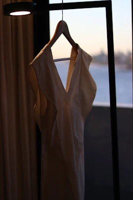 A serene image of a delicate, modest dress hanging softly in natural light, reflecting purity and elegance.