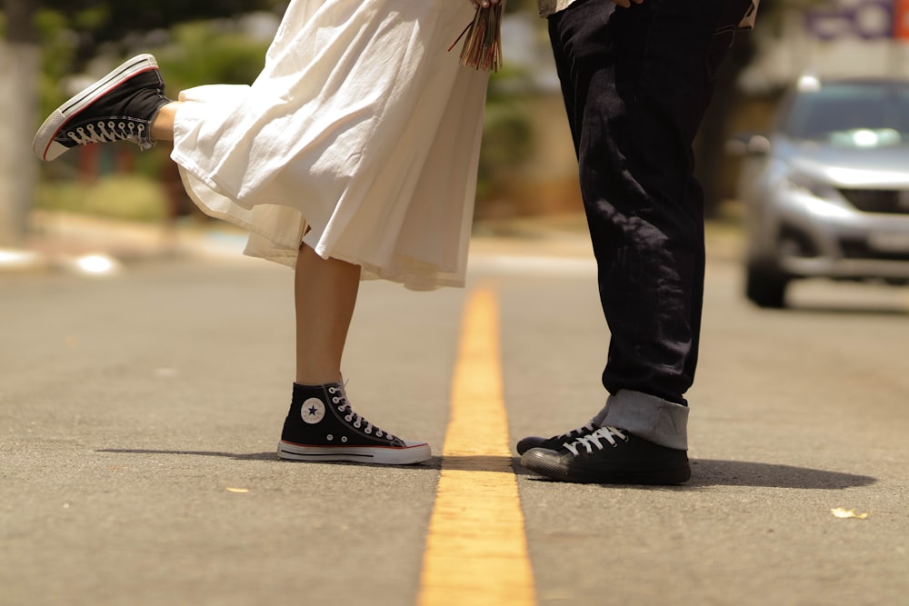 a man and a woman standing on the side of a road