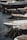 Several luxury yachts are docked in a marina, with their sleek designs and polished surfaces. The yachts are lined up closely, each tied with ropes to the dock. The water reflects the hulls of the boats, creating a calm and serene atmosphere.