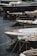 Several luxury yachts are docked in a marina, with their sleek designs and polished surfaces. The yachts are lined up closely, each tied with ropes to the dock. The water reflects the hulls of the boats, creating a calm and serene atmosphere.