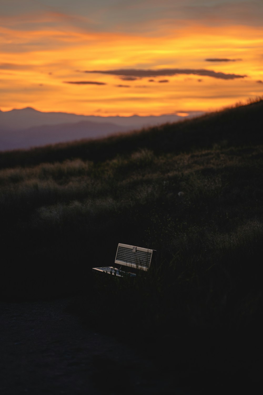 a laptop computer sitting on top of a grass covered hillside