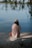 a woman sitting on a rock near the water