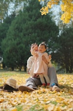A candid moment of laughter shared between a father and daughter sitting on a cozy bench surrounded by autumn leaves.