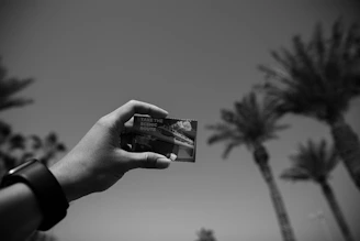 A sleek rounded card featuring a cinematic shot of a travel influencer filming at a luxury mountain resort.