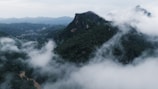 A majestic mountain landscape with lush greenery and mist.