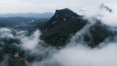 A majestic mountain landscape with lush greenery and mist.