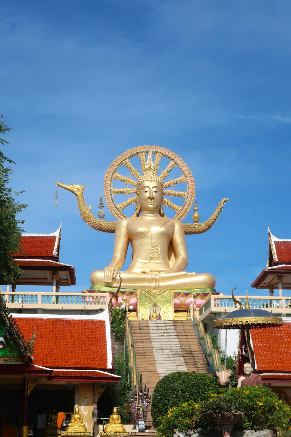 a large golden buddha statue sitting in front of a building