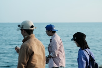A group of people wearing casual caps outdoors on a sunny day.