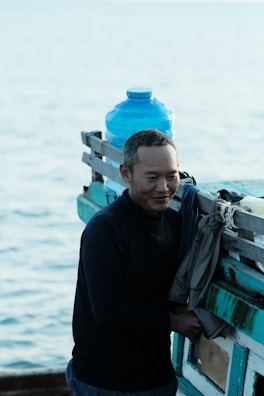 A smiling technician checking water levels on a boat during delivery.