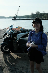 A happy tourist receiving keys from a jyoride staff member beside a row of scooters.