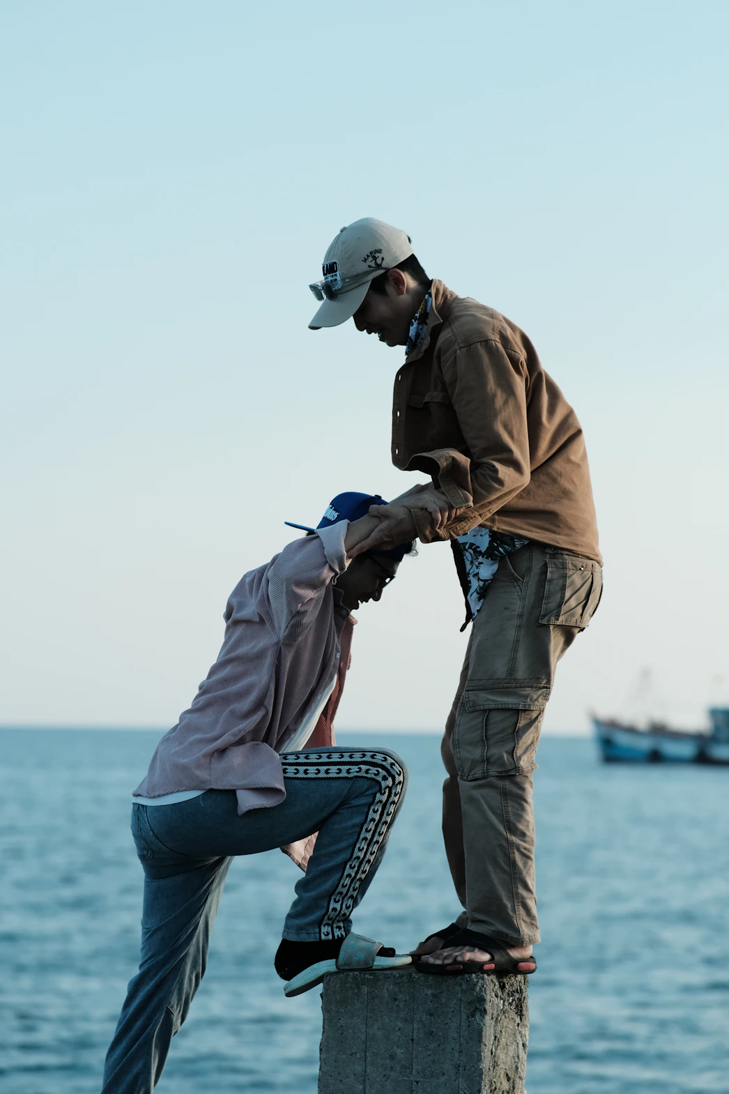 a man helping another man stand on a dock